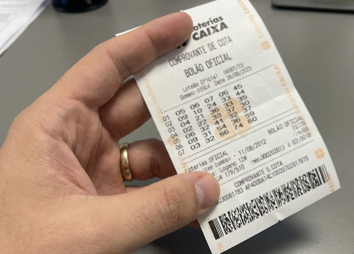 M&atilde;o segurando comprovante oficial de cota de bol&atilde;o