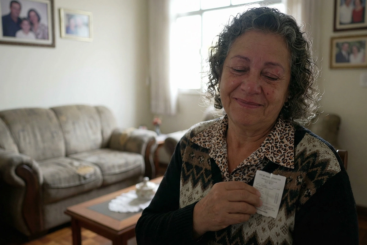 Pessoa sorridente segurando bilhete premiado de loteria